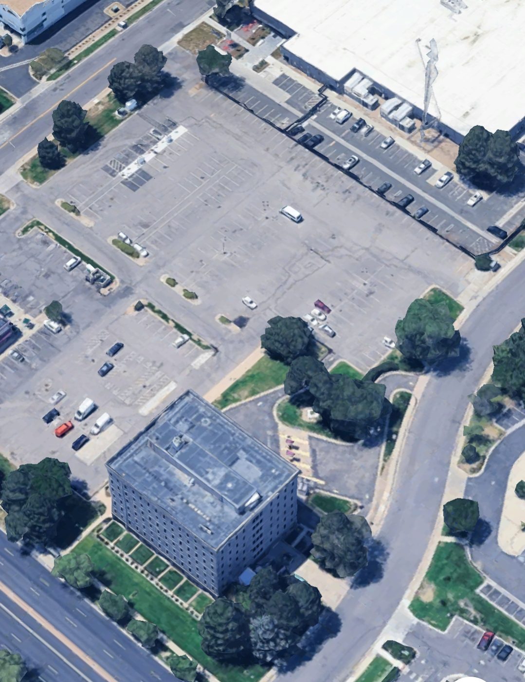 Aerial view of the building and the surface parking field around it