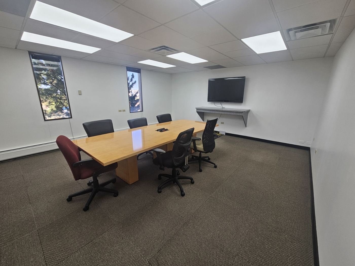 Floor 4 conference room with table, chairs, and wall display