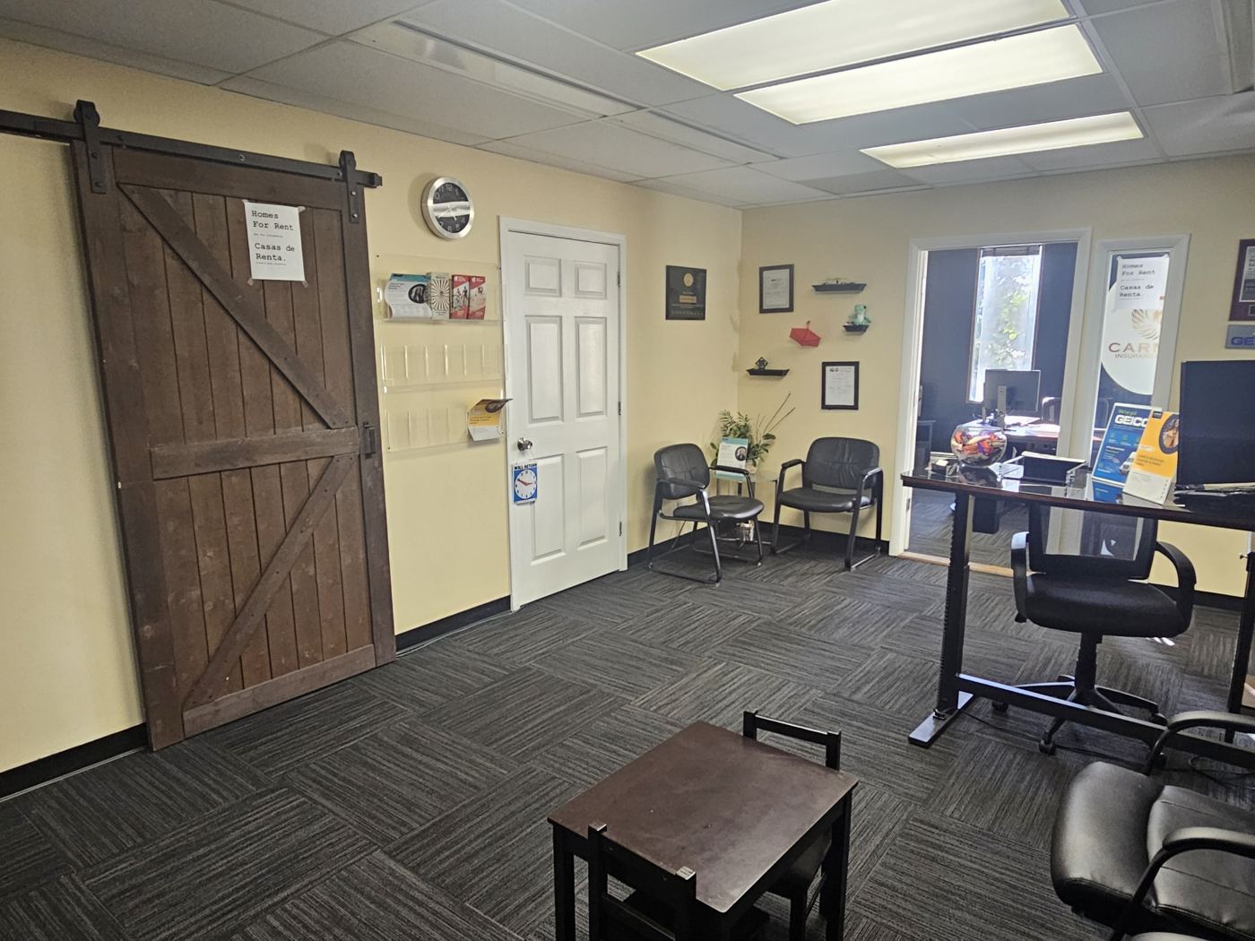 Reception area of a finished Floor 3 suite with a sliding barn door and seating